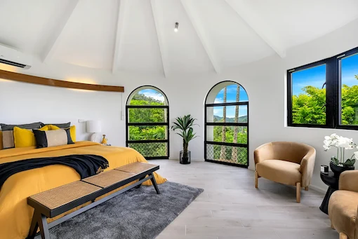 Stunning bedroom with arched windows and yellow bedding, professionally edited for Australian property listings.